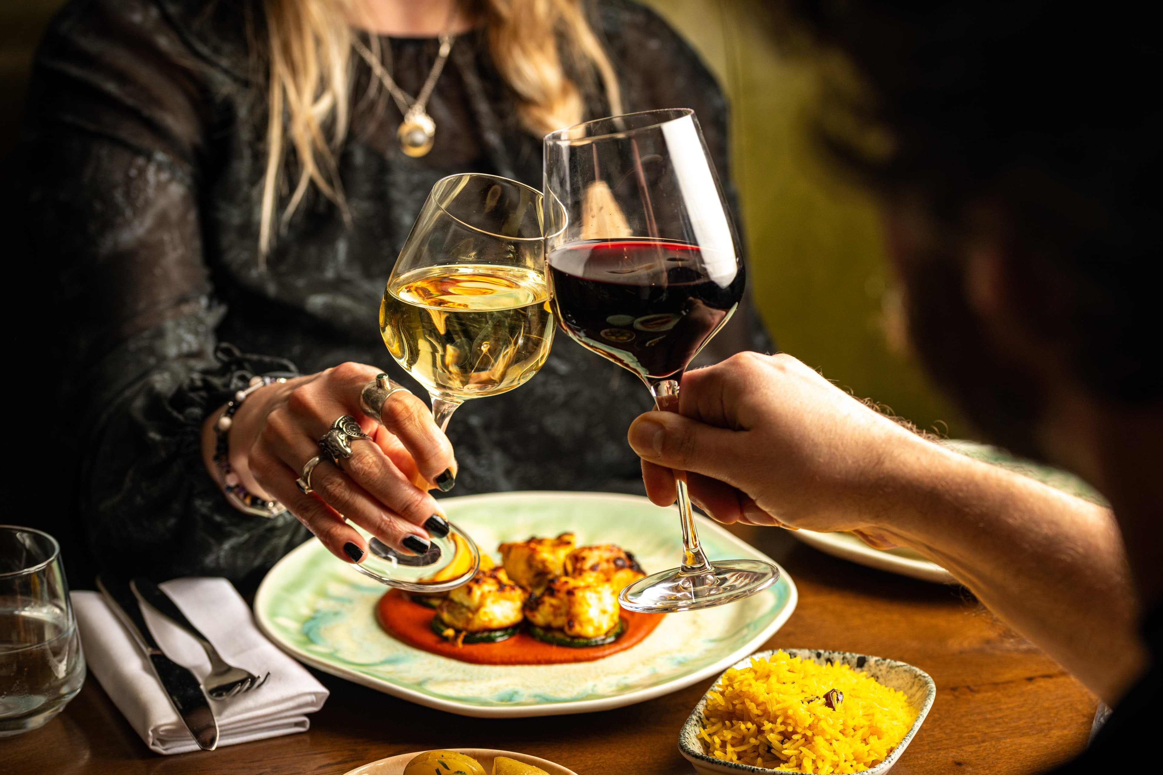 Guests raising a glass over a Mediterranean meal at Olea Social